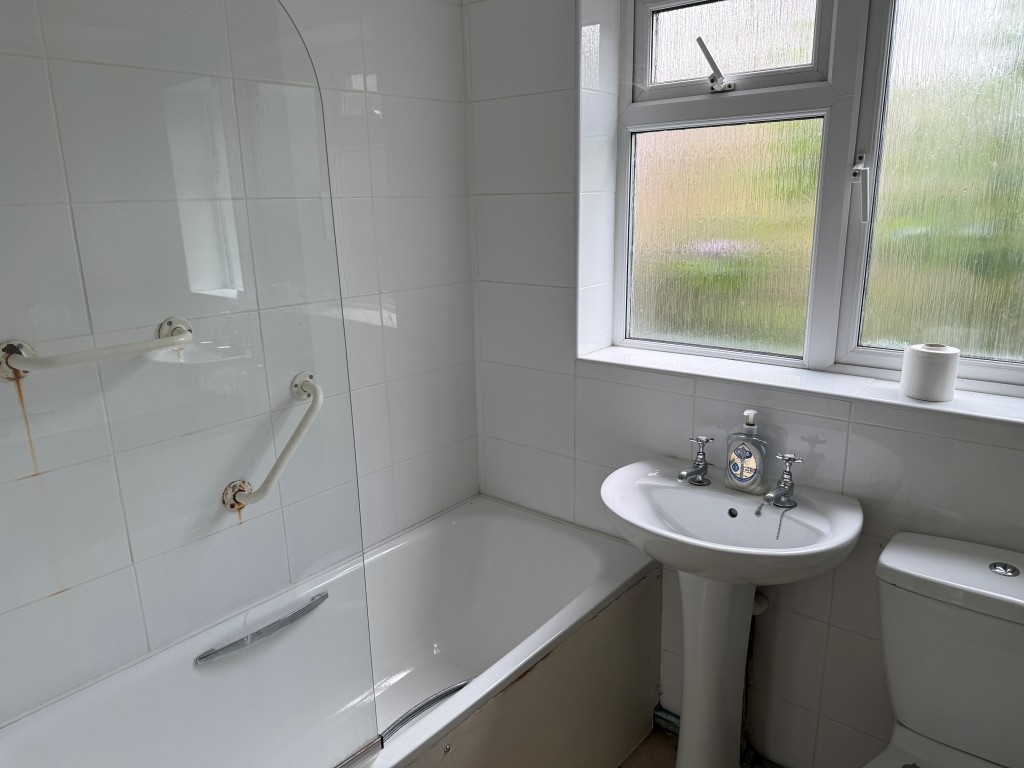 Lot: 88 - GROUND FLOOR FLAT WITH GARAGE IN NEED OF UPDATING - White bathroom unit with sink and WC